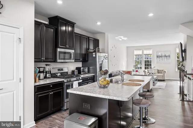 a kitchen with a stove a sink a dining table and chairs