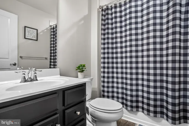 a bathroom with a sink mirror vanity and toilet