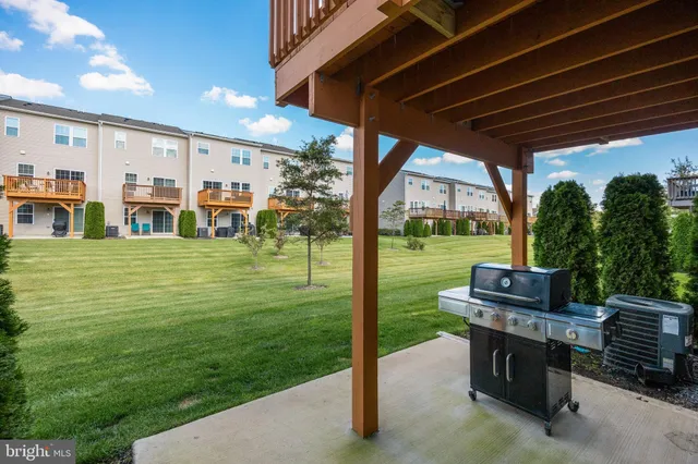 a view of a patio with table and chairs potted plants and a palm tree