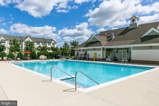 a view of a house with pool and chairs
