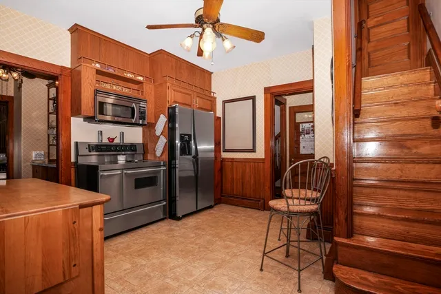 a kitchen with stainless steel appliances granite countertop a refrigerator and a stove top oven