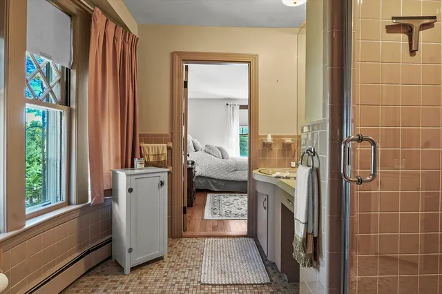 a bathroom with a sink a mirror and next to a window