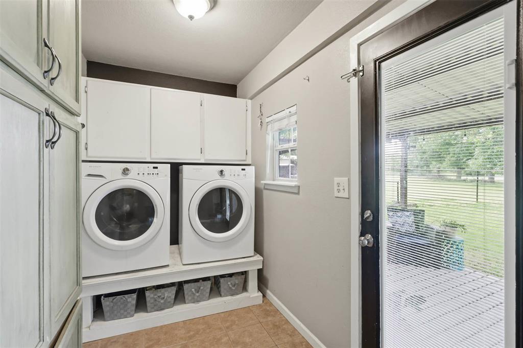 308 West 1st Street Springtown, TX 76082 - Photo 26 of 39 Dedicated laundry area featuring a tile floor and white cabinetry