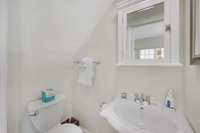 a bathroom with a sink toilet and mirror