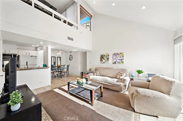 a living room with furniture and a dining table with kitchen view