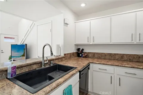 a kitchen with granite countertop a sink a stove and cabinets