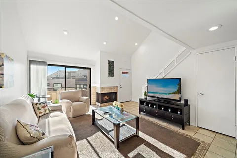 a living room with furniture a flat screen tv and a floor to ceiling window