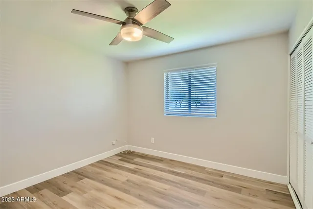 an empty room with a window and a fan