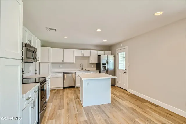 a kitchen with white cabinets and stainless steel appliances