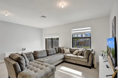 a living room with furniture and a dining table with kitchen view