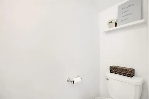 a living room with stainless steel appliances furniture a rug and a kitchen view