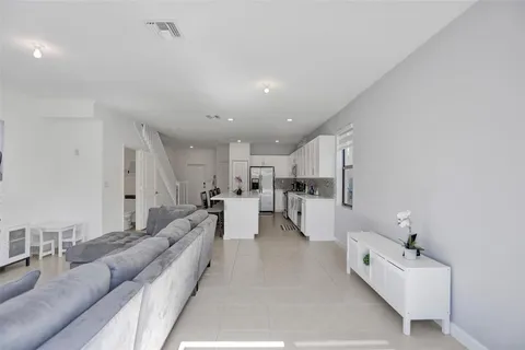 a living room with furniture and a view of kitchen
