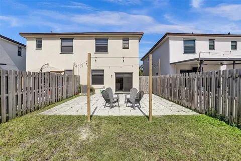 a view of a house with backyard and wooden fence