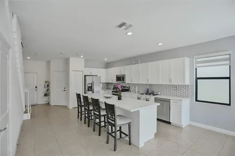 a kitchen with a sink and chairs