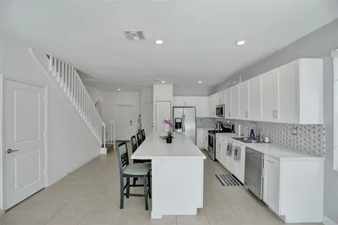 a kitchen with white cabinets and white appliances
