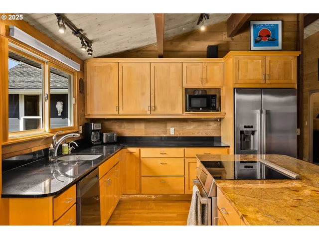a kitchen with stainless steel appliances kitchen island granite countertop a sink and cabinets