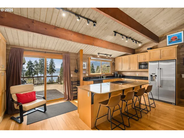 a dining hall with stainless steel appliances kitchen island granite countertop a table and chairs