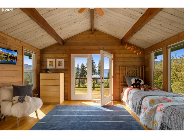 a bedroom with furniture and large windows