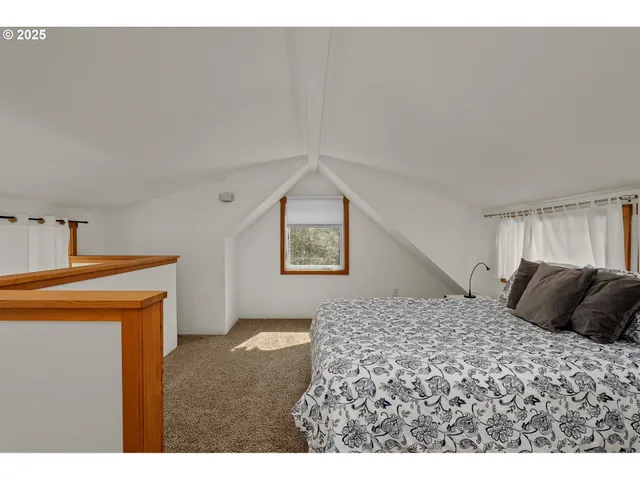 a bedroom with a bed and a lamp on dresser