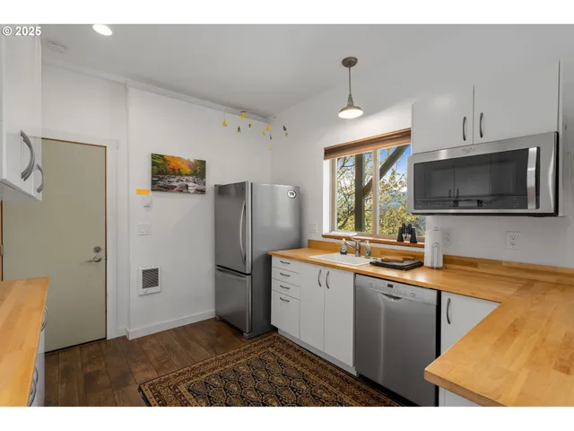 a kitchen with stainless steel appliances a refrigerator sink and microwave