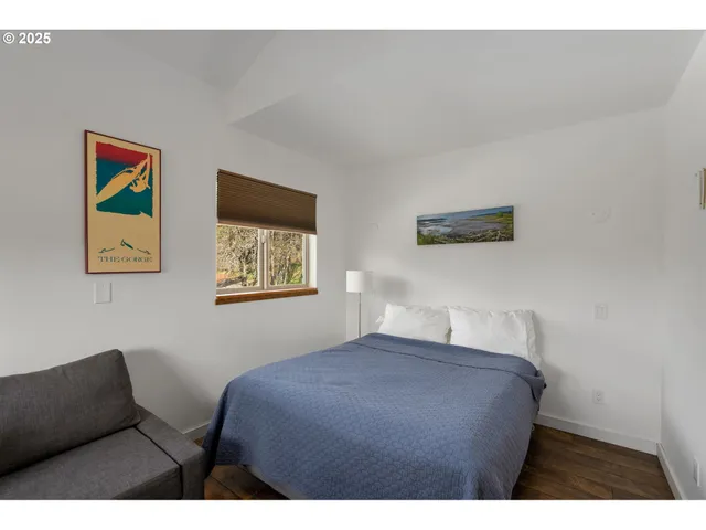 a bedroom with a bed and painting on the wall