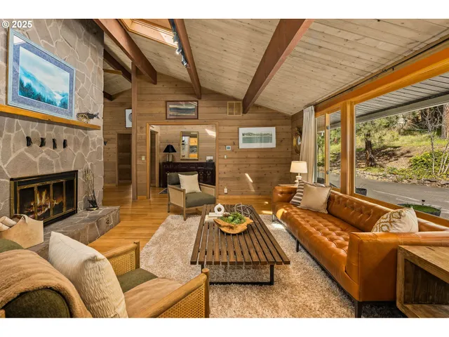 a living room with furniture fireplace and a large window