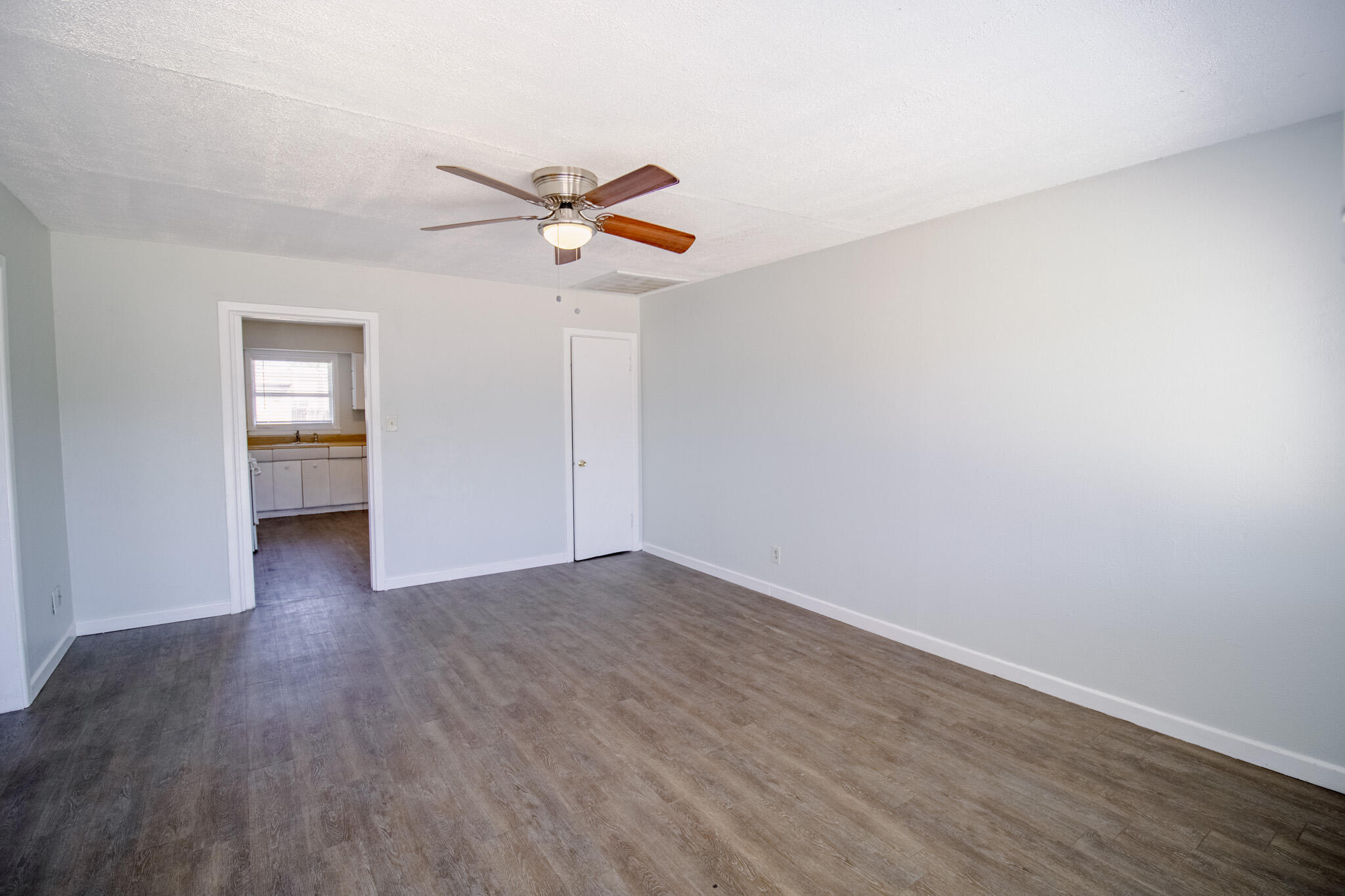 2906 43rd Street, Unit B Lubbock, TX 79413 - Photo 2 of 8 a view of empty room with wooden floor and fan