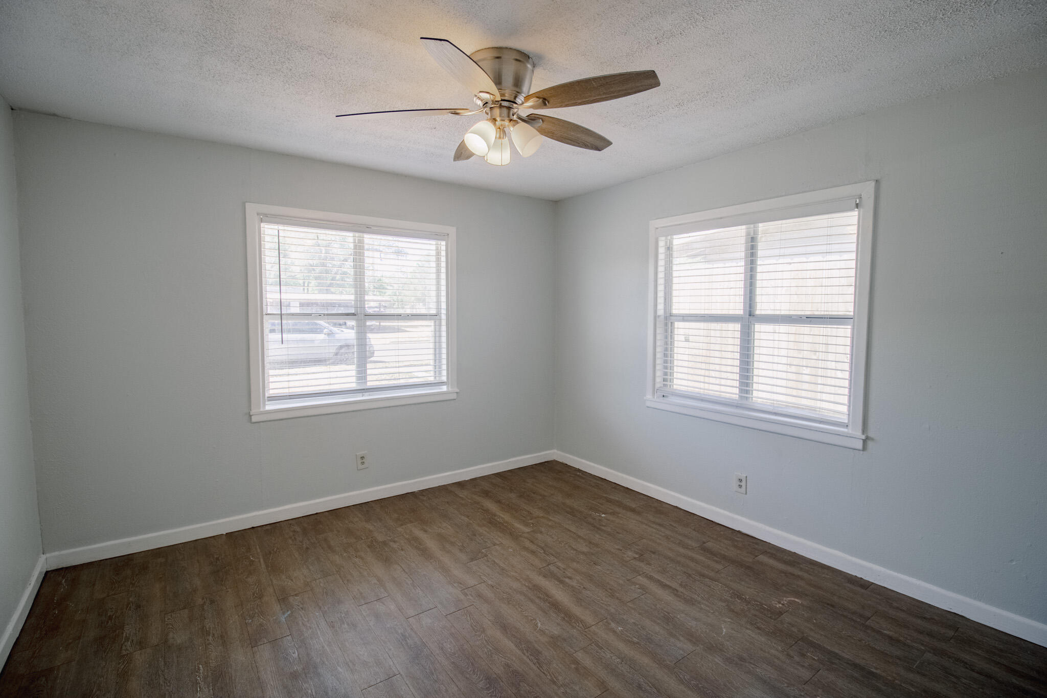 2906 43rd Street, Unit B Lubbock, TX 79413 - Photo 3 of 8 an empty room with wooden floor and windows