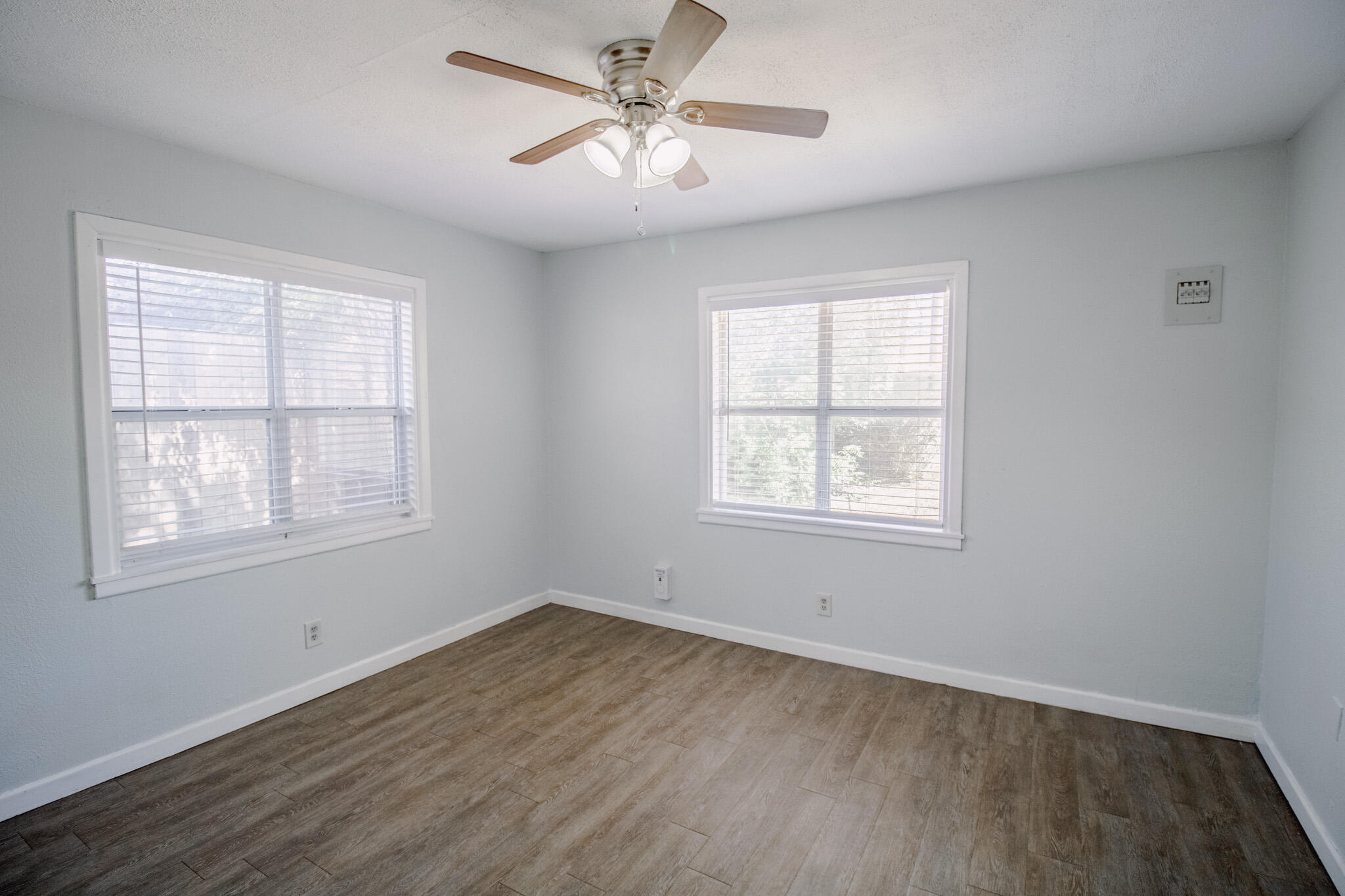 2906 43rd Street, Unit B Lubbock, TX 79413 - Photo 5 of 8 a view of an empty room with a window and wooden floor
