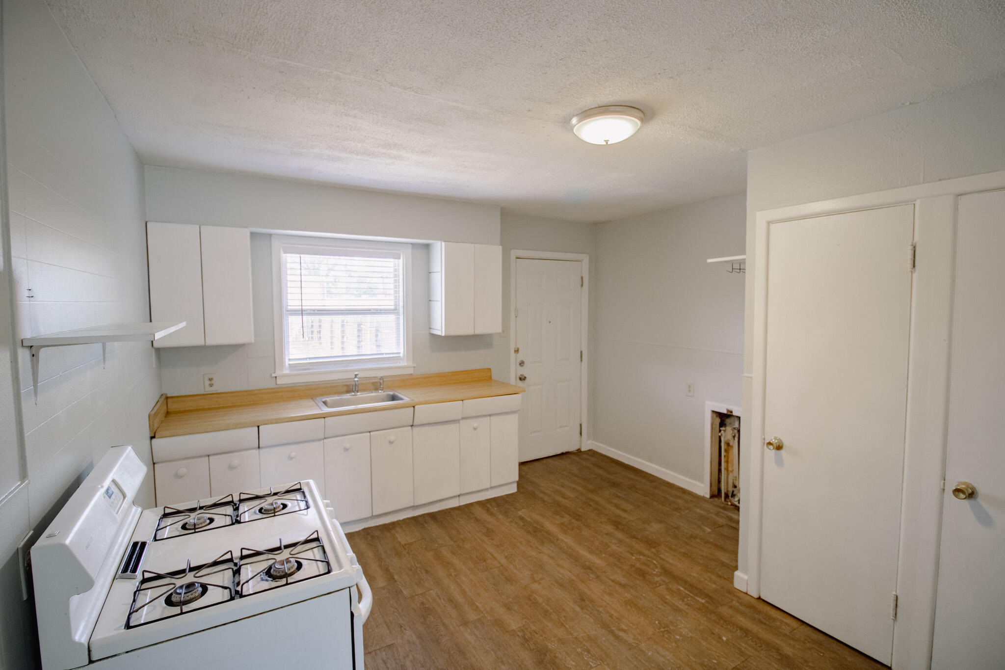 2906 43rd Street, Unit B Lubbock, TX 79413 - Photo 7 of 8 a view of kitchen with wooden floor and electronic appliances