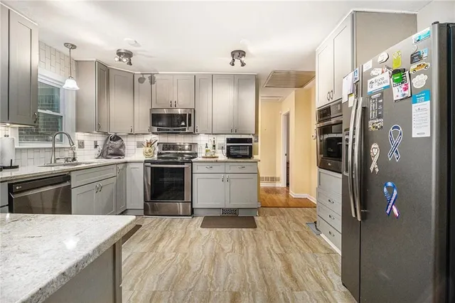 a kitchen with stainless steel appliances granite countertop a sink stove and cabinets