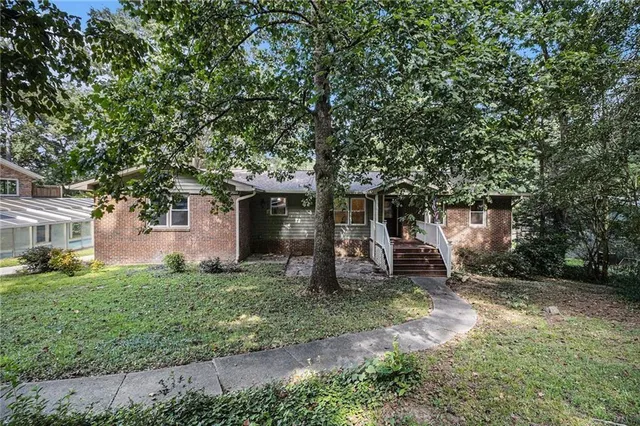 a front view of a house with a yard and trees
