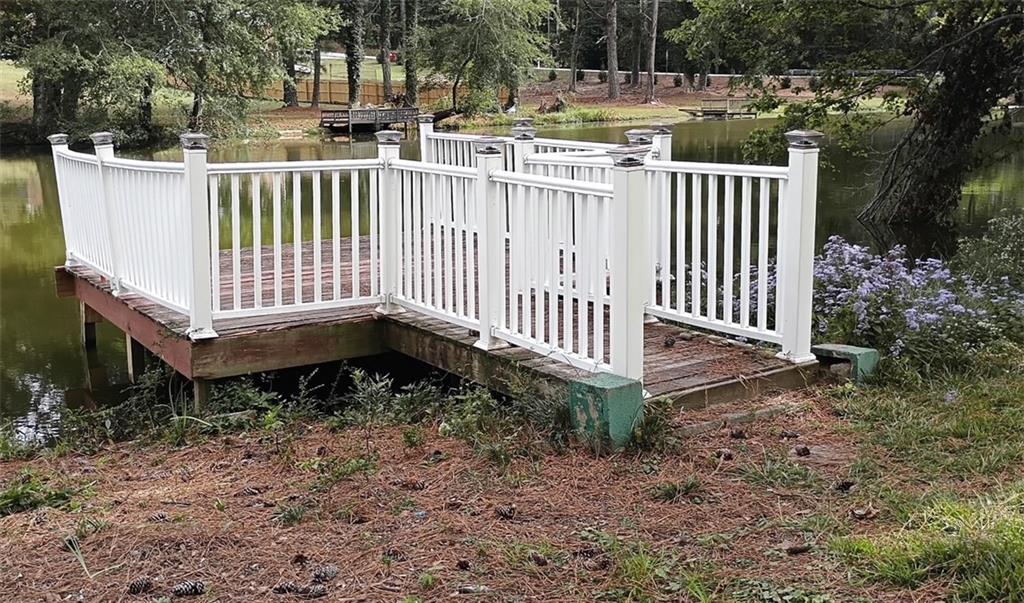 2545 Rockbridge Road Northwest Conyers, GA 30012 - Photo 60 of 61 a view of a wooden house with yard and a wooden fence