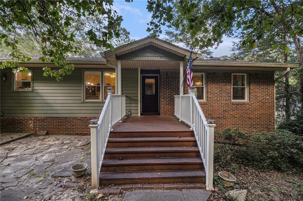 2545 Rockbridge Road Northwest Conyers, GA 30012 - Photo 7 of 61 a front view of a house with wooden stairs and a large tree
