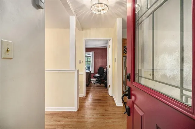 a view of a hallway with wooden floor and staircase