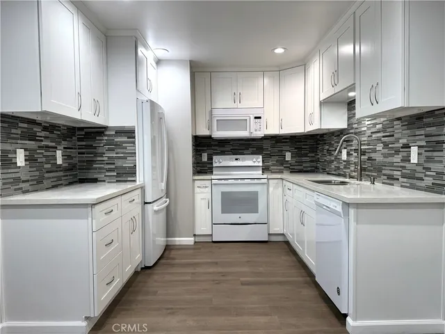 a kitchen with white cabinets stainless steel appliances and a sink