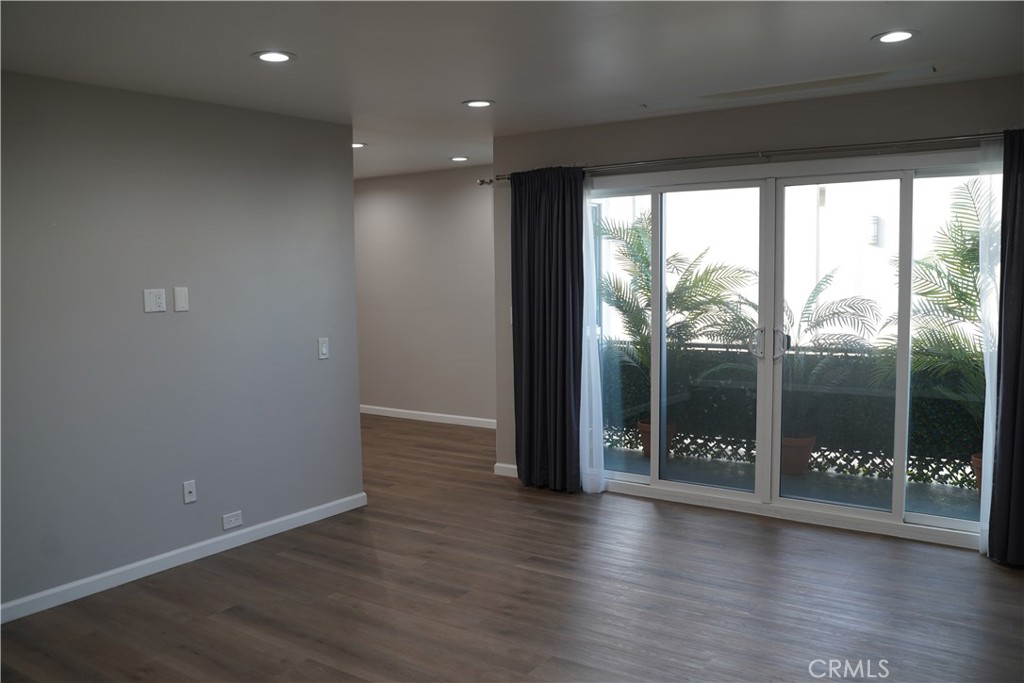 3939 East Allin, Unit 109 Long Beach, CA 90803 - Photo 4 of 21 an empty room with wooden floor and outdoor view