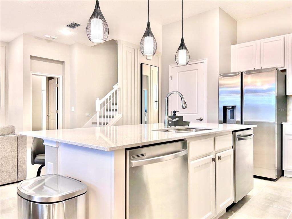 6271 Sand Skipper Road Orlando, FL 32821 - Photo 12 of 46 a kitchen with kitchen island a sink and a chandelier