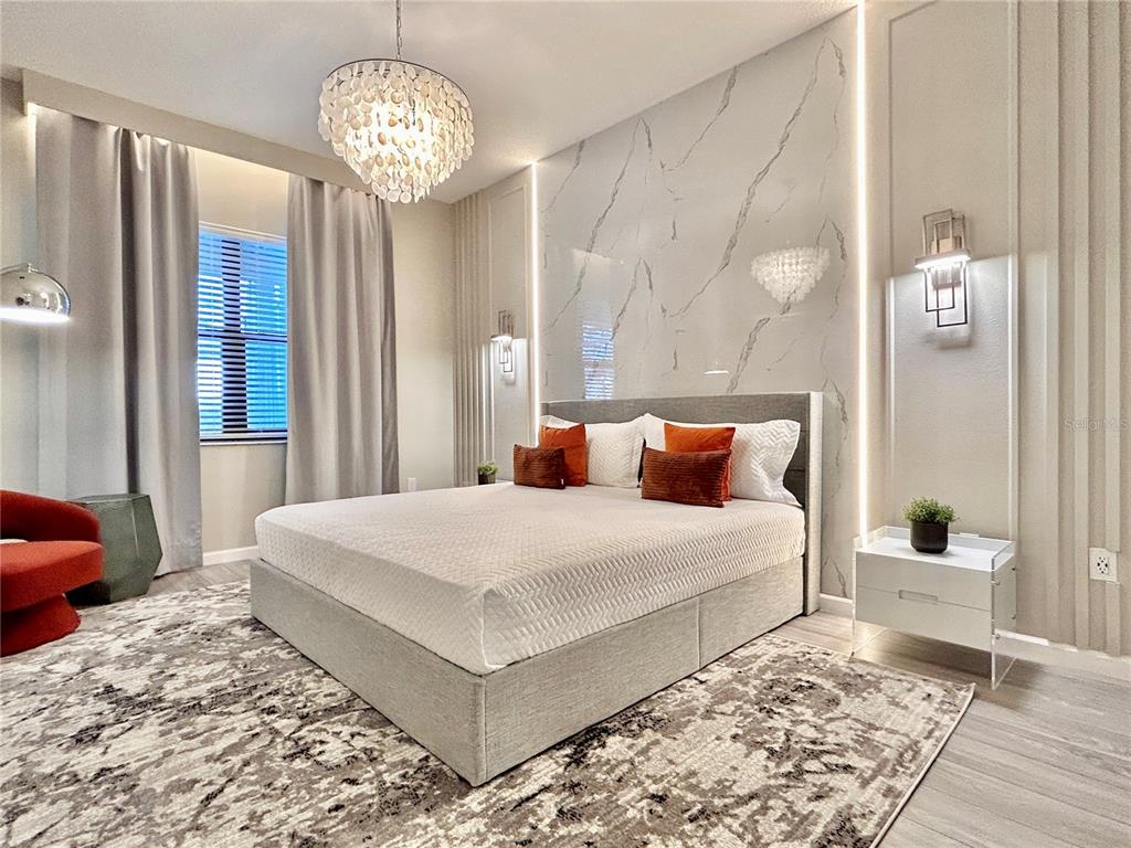 6271 Sand Skipper Road Orlando, FL 32821 - Photo 13 of 46 a bedroom with a large bed and a chandelier