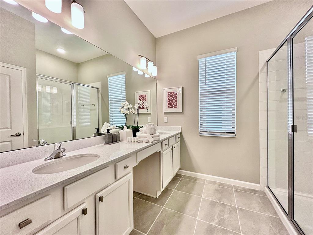 6271 Sand Skipper Road Orlando, FL 32821 - Photo 15 of 46 a spacious bathroom with a double vanity sink a mirror and a bathtub