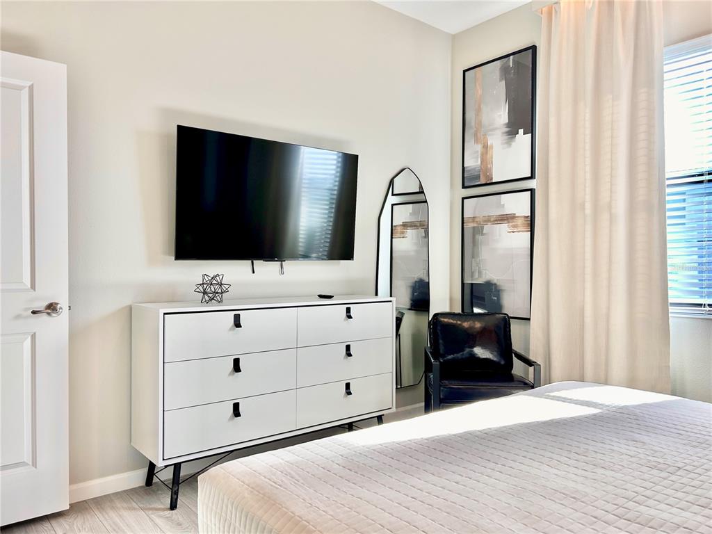 6271 Sand Skipper Road Orlando, FL 32821 - Photo 20 of 46 a bedroom with a bed and a flat screen tv