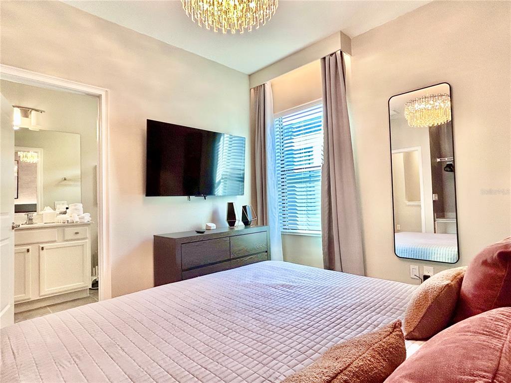 6271 Sand Skipper Road Orlando, FL 32821 - Photo 23 of 46 a bedroom with a bed and a flat screen tv