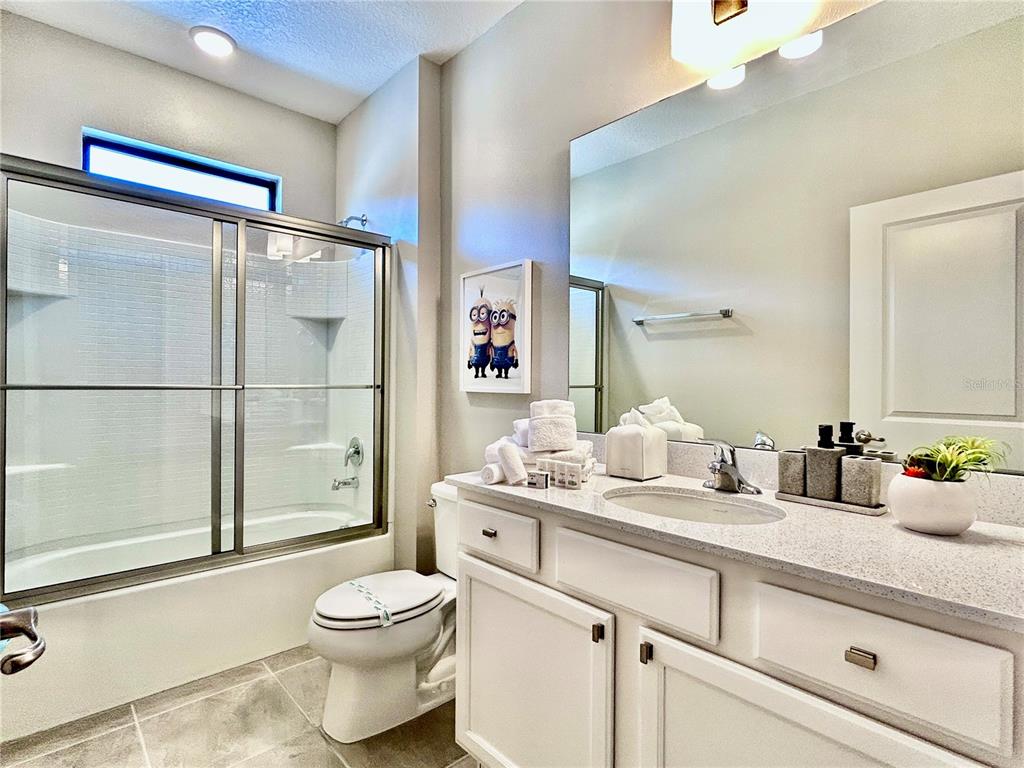 6271 Sand Skipper Road Orlando, FL 32821 - Photo 29 of 46 a bathroom with a granite countertop sink mirror vanity and toilet
