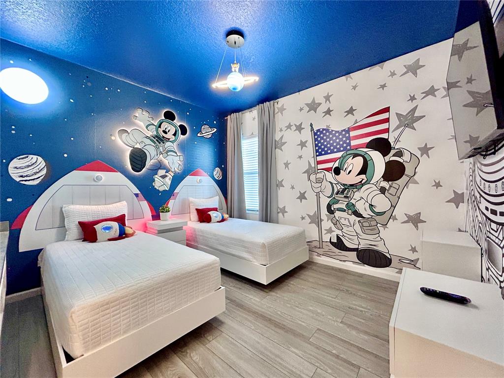 6271 Sand Skipper Road Orlando, FL 32821 - Photo 30 of 46 a bedroom with a bed and a chandelier