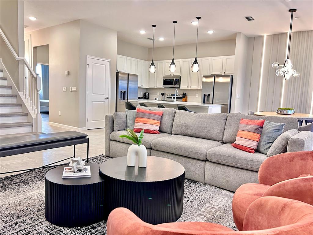 6271 Sand Skipper Road Orlando, FL 32821 - Photo 8 of 46 a living room with furniture kitchen and a chandelier