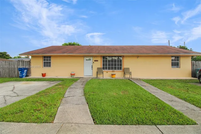 a view of a house with a yard and a garden