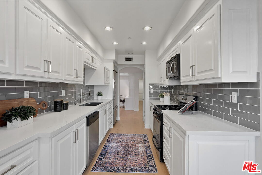 1629 Armacost Avenue, Unit 101 Los Angeles, CA 90025 - Photo 13 of 26 a kitchen with a sink stove and cabinets