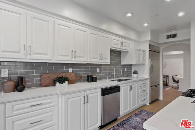 a kitchen with white cabinets and white appliances