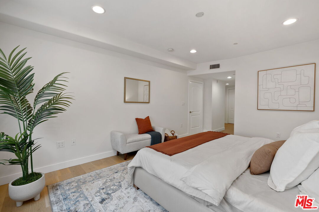 1629 Armacost Avenue, Unit 101 Los Angeles, CA 90025 - Photo 18 of 26 a bedroom with a large bed and a potted plant