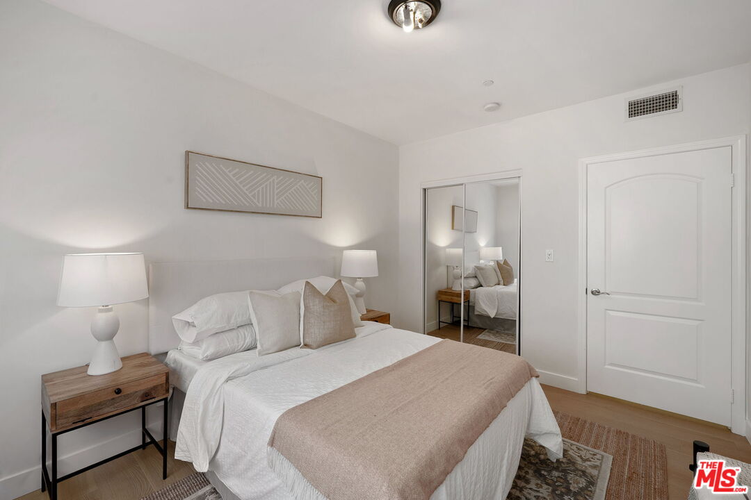 1629 Armacost Avenue, Unit 101 Los Angeles, CA 90025 - Photo 22 of 26 a bedroom with a bed and a lamp